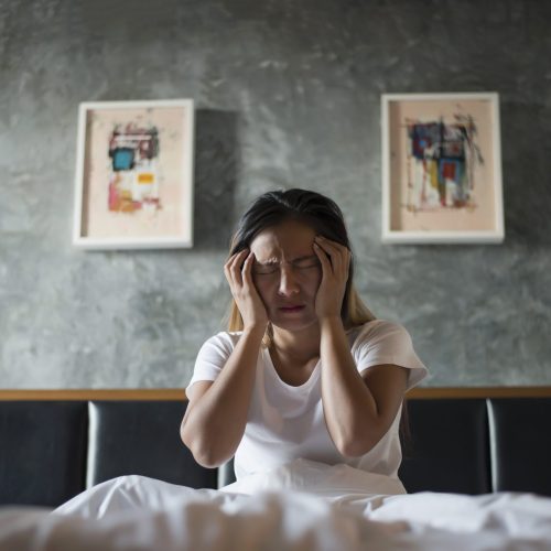 Depressed woman with headache hand holding her head on the bed Depressed woman with headache hand holding her head on the bed